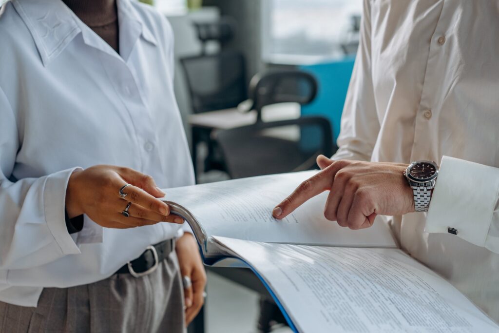 Consulting & Audits. Two business people reviewing a large report.